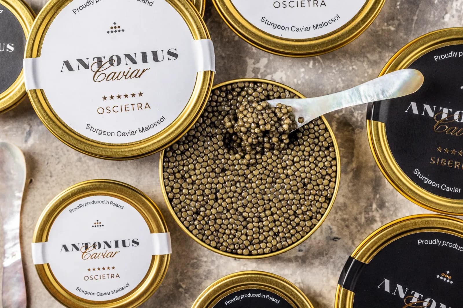 Overhead view of Antonius Caviar Oscietra and Siberian tins with a mother-of-pearl spoon